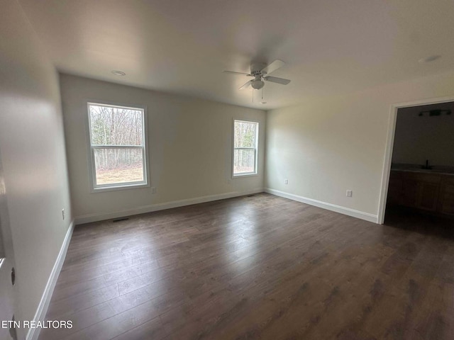 unfurnished room featuring ceiling fan and dark wood-type flooring