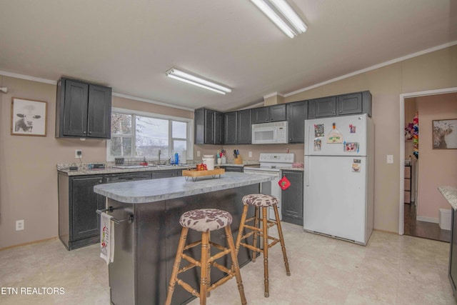 kitchen featuring a center island, crown molding, lofted ceiling, white appliances, and a breakfast bar area