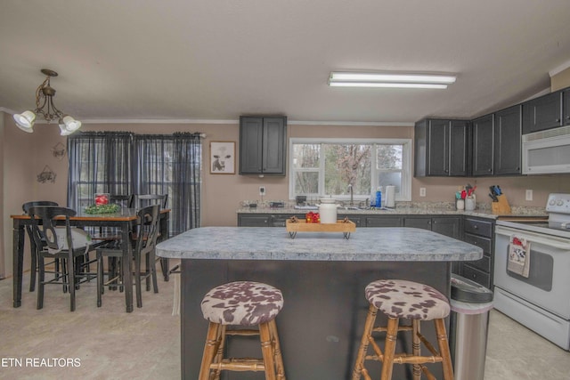 kitchen featuring a breakfast bar, a center island, white appliances, and decorative light fixtures