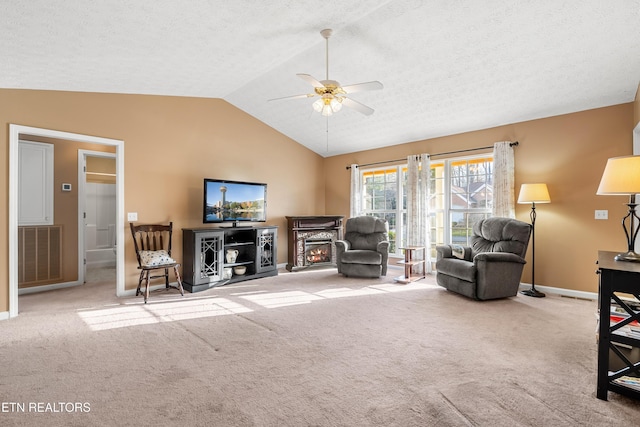 carpeted living room featuring a textured ceiling, ceiling fan, and vaulted ceiling