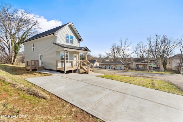 rear view of property with covered porch and a lawn