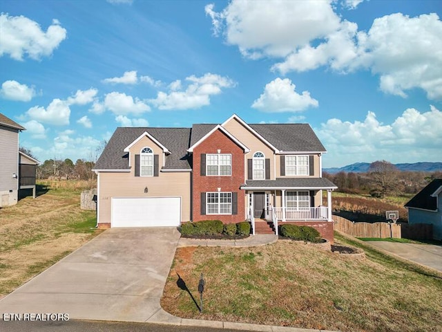 view of front of property with a front yard, a porch, a garage, and a mountain view