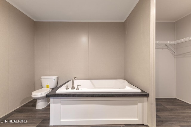 bathroom featuring hardwood / wood-style flooring, toilet, and a bath