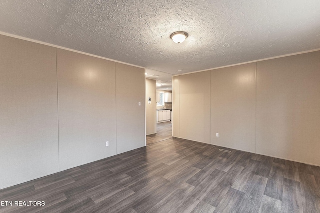 unfurnished room featuring a textured ceiling, dark hardwood / wood-style flooring, and ornamental molding