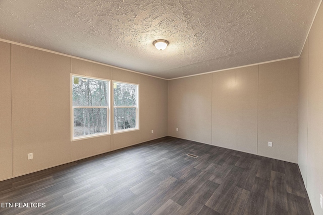 empty room featuring a textured ceiling, dark wood-type flooring, and crown molding