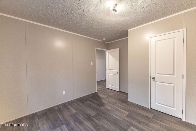 unfurnished room with dark wood-type flooring, a textured ceiling, and ornamental molding