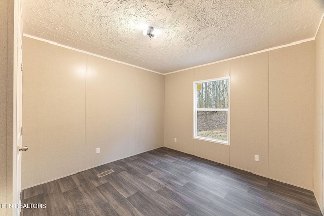 unfurnished room with dark hardwood / wood-style flooring, ornamental molding, and a textured ceiling