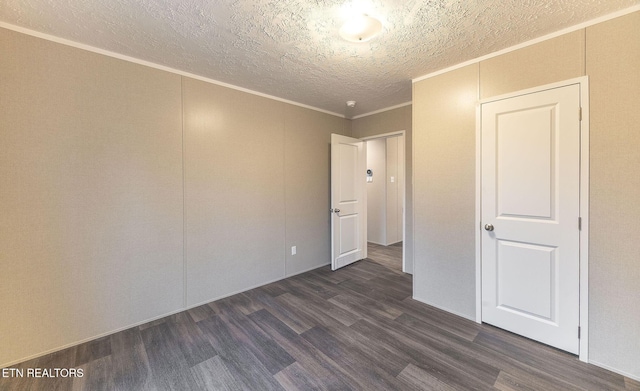 empty room featuring crown molding, dark wood-type flooring, and a textured ceiling