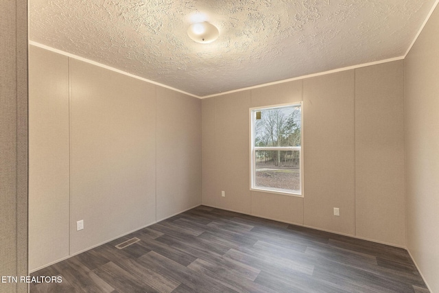 empty room featuring a textured ceiling, crown molding, and dark hardwood / wood-style floors