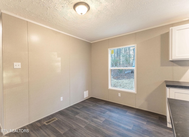 unfurnished dining area with a textured ceiling and dark hardwood / wood-style floors