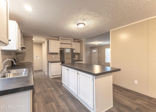 kitchen featuring stainless steel refrigerator, sink, white cabinets, and dark hardwood / wood-style flooring