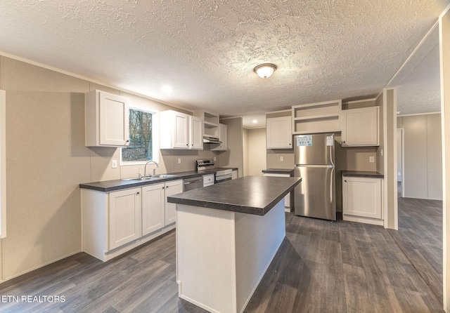 kitchen with white cabinets, a center island, stainless steel appliances, and sink