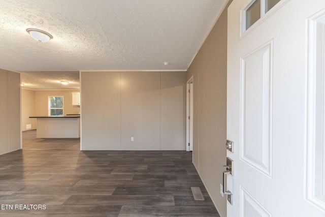 spare room featuring dark hardwood / wood-style flooring and a textured ceiling