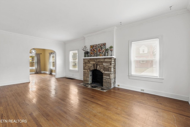 unfurnished living room with wood-type flooring, ornamental molding, and a fireplace