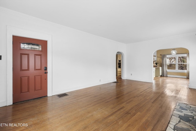 unfurnished living room featuring hardwood / wood-style flooring and ornamental molding