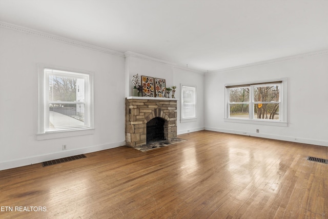 unfurnished living room featuring a stone fireplace, wood-type flooring, and crown molding