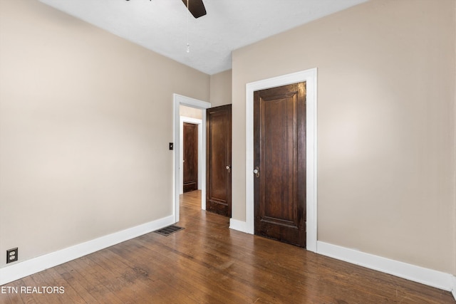 unfurnished bedroom featuring dark hardwood / wood-style flooring and ceiling fan