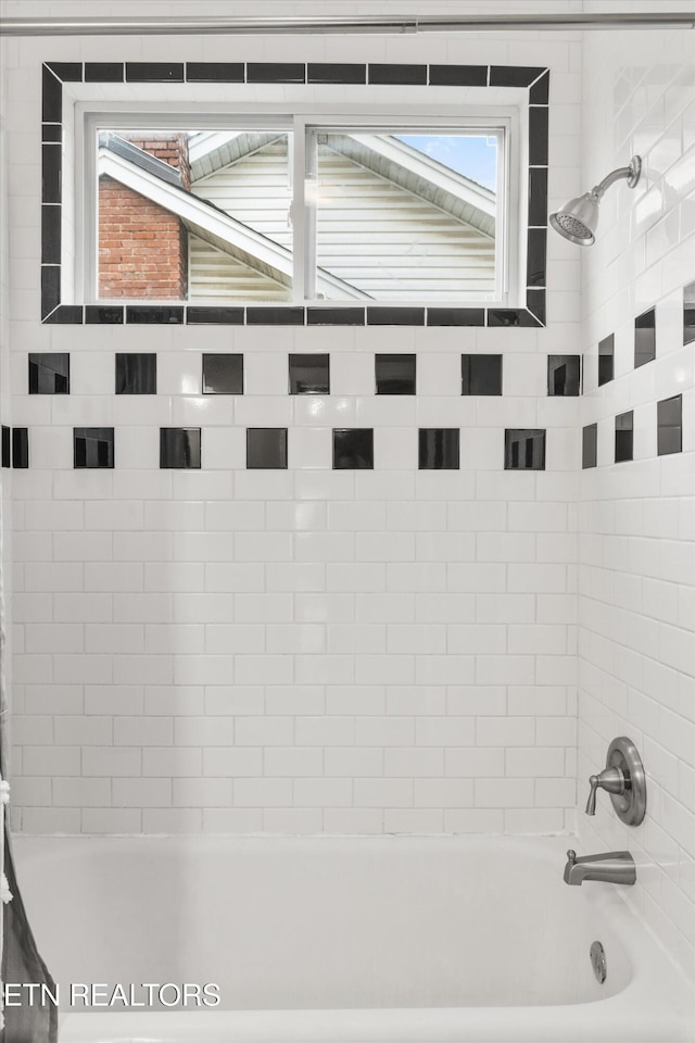 interior details with tiled shower / bath combo