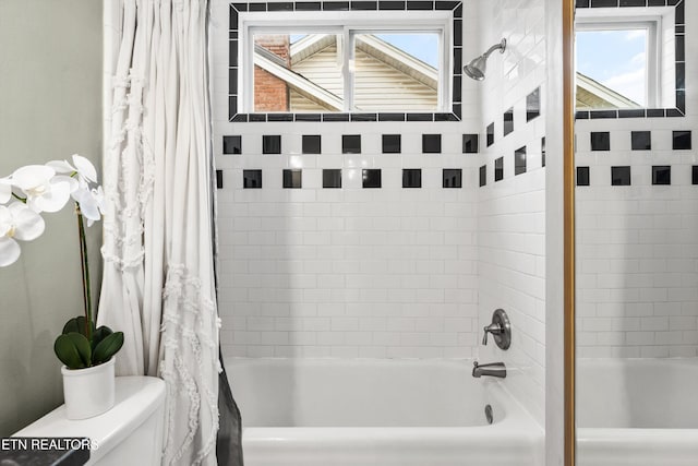 bathroom featuring toilet and shower / bath combo with shower curtain