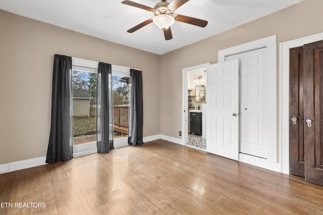 unfurnished bedroom with ceiling fan, light wood-type flooring, and ensuite bath