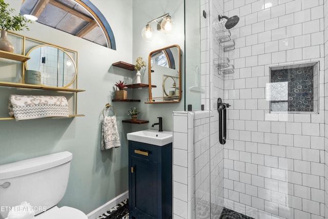 bathroom featuring vanity, toilet, and a shower with shower door