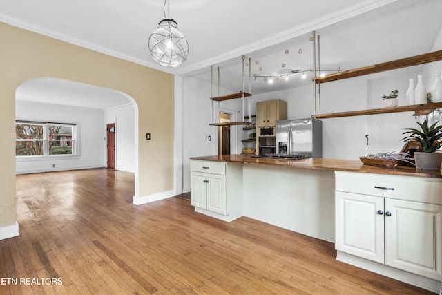 kitchen with stainless steel fridge with ice dispenser, pendant lighting, butcher block counters, and white cabinetry