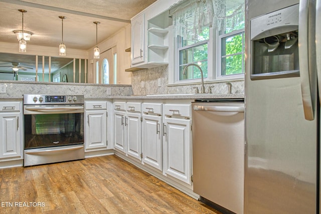 kitchen with ceiling fan, white cabinets, pendant lighting, and appliances with stainless steel finishes