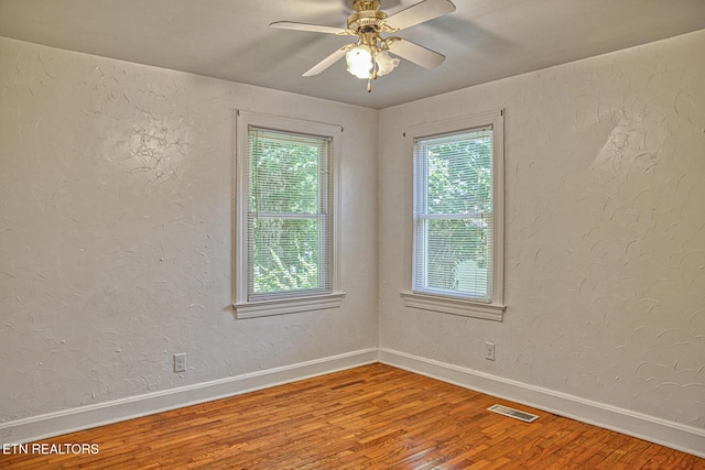 unfurnished room with hardwood / wood-style flooring, plenty of natural light, and ceiling fan