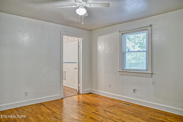 empty room with ceiling fan and hardwood / wood-style floors