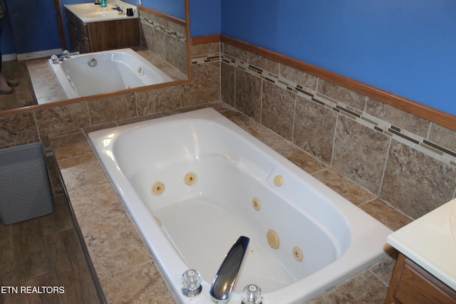 bathroom featuring vanity and a relaxing tiled tub