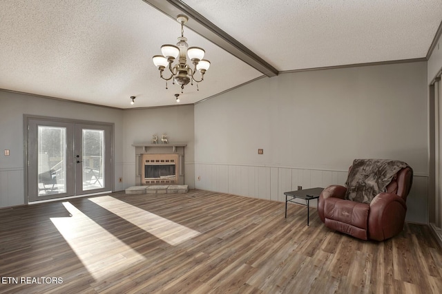 unfurnished living room featuring hardwood / wood-style flooring, lofted ceiling with beams, a textured ceiling, and an inviting chandelier