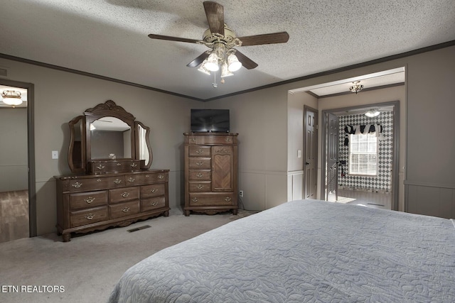 carpeted bedroom featuring ceiling fan, crown molding, and a textured ceiling