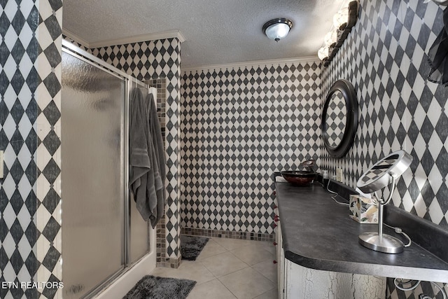 bathroom featuring tile patterned flooring, a textured ceiling, a shower with door, and crown molding