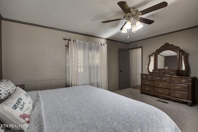 carpeted bedroom with a textured ceiling, ceiling fan, and ornamental molding