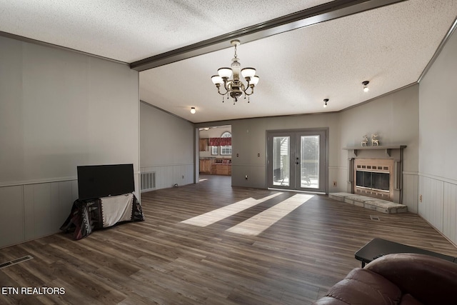 living room featuring a fireplace, a textured ceiling, a chandelier, and crown molding