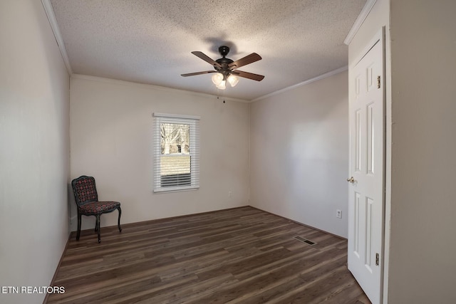 spare room with a textured ceiling, ceiling fan, crown molding, and dark wood-type flooring