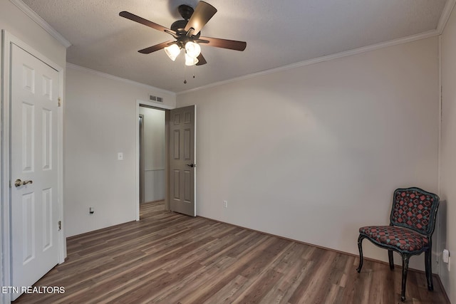 bedroom featuring ceiling fan, dark hardwood / wood-style flooring, crown molding, and a textured ceiling