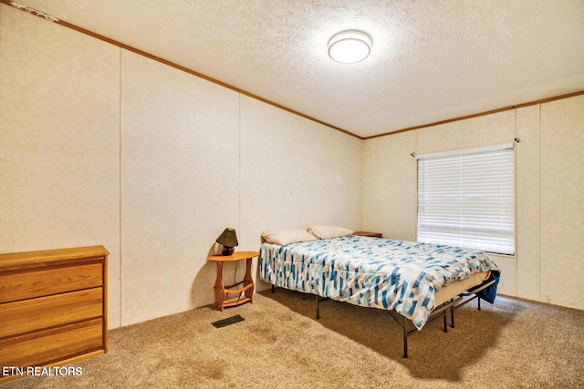 bedroom with a textured ceiling, carpet floors, and crown molding