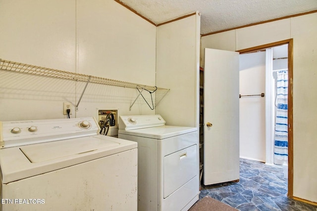 clothes washing area with washer and clothes dryer and ornamental molding