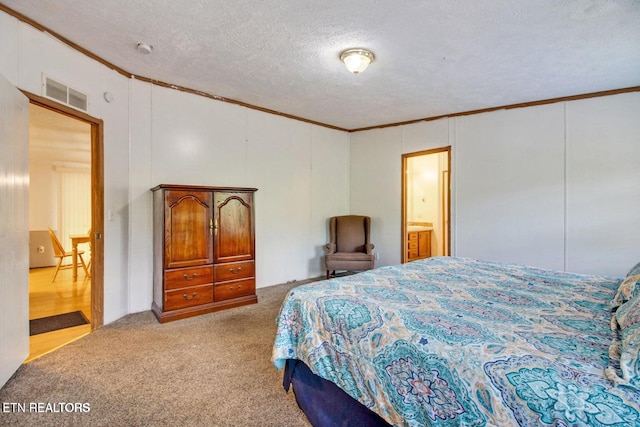 bedroom with light carpet, a textured ceiling, ensuite bath, and crown molding