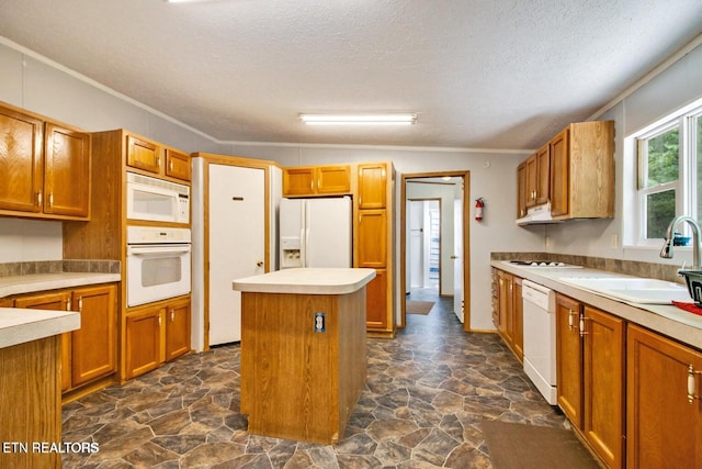 kitchen with a textured ceiling, white appliances, vaulted ceiling, sink, and a kitchen island