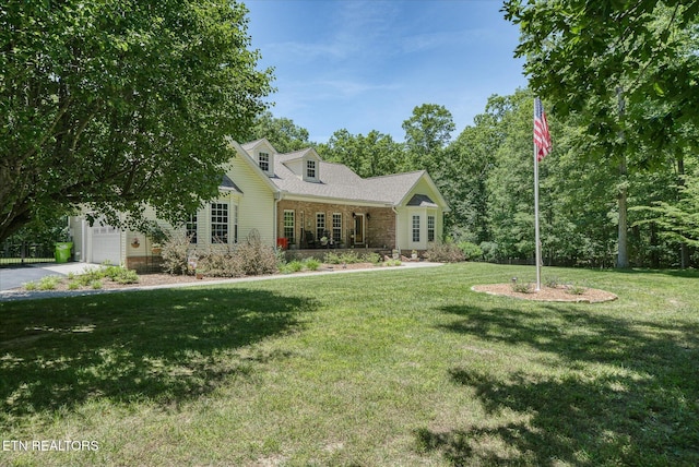 new england style home featuring a front yard and a garage