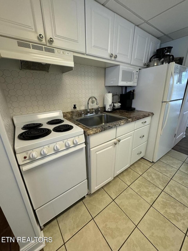 kitchen featuring a paneled ceiling, white appliances, sink, white cabinets, and light tile patterned flooring