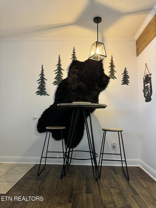 dining room featuring a textured ceiling, dark wood-type flooring, and crown molding