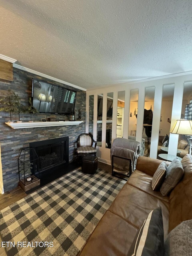 living room featuring a fireplace, a textured ceiling, and ornamental molding