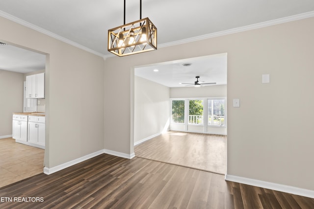 unfurnished room featuring ceiling fan, dark hardwood / wood-style flooring, and ornamental molding