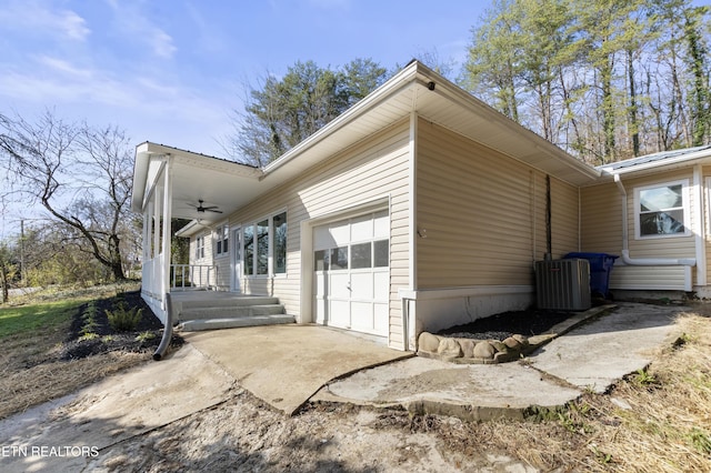 view of property exterior with central air condition unit and a garage