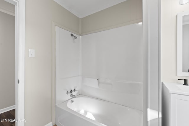 bathroom with bathtub / shower combination, hardwood / wood-style floors, vanity, and crown molding