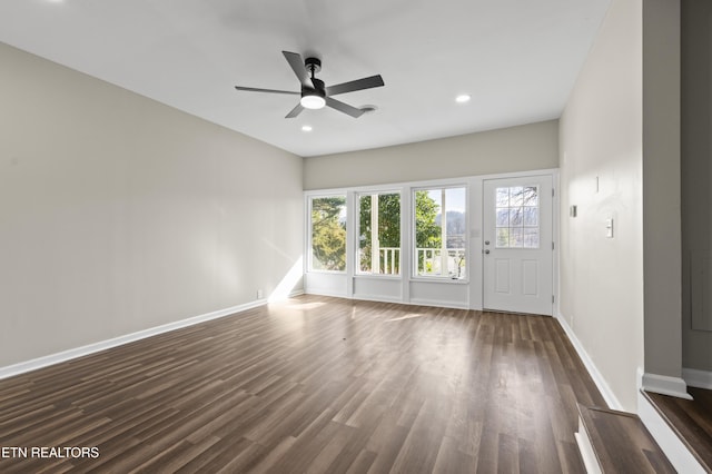 unfurnished living room featuring dark hardwood / wood-style flooring and ceiling fan