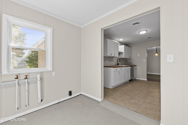 kitchen with dishwasher, sink, crown molding, and wooden counters